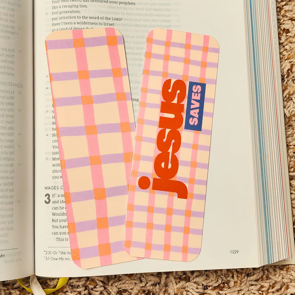 Plaid bookmarks with 'jesus saves' text on an open book